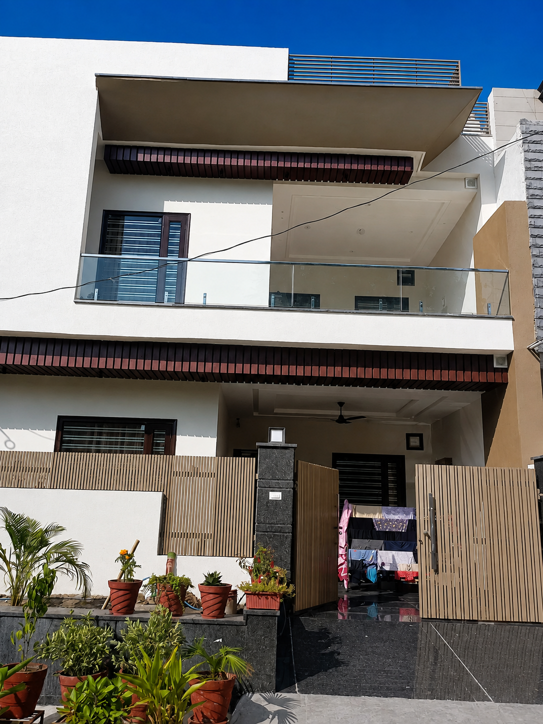 Vertical metal boundary louvers and glass balcony by Lotey Metalcrafts