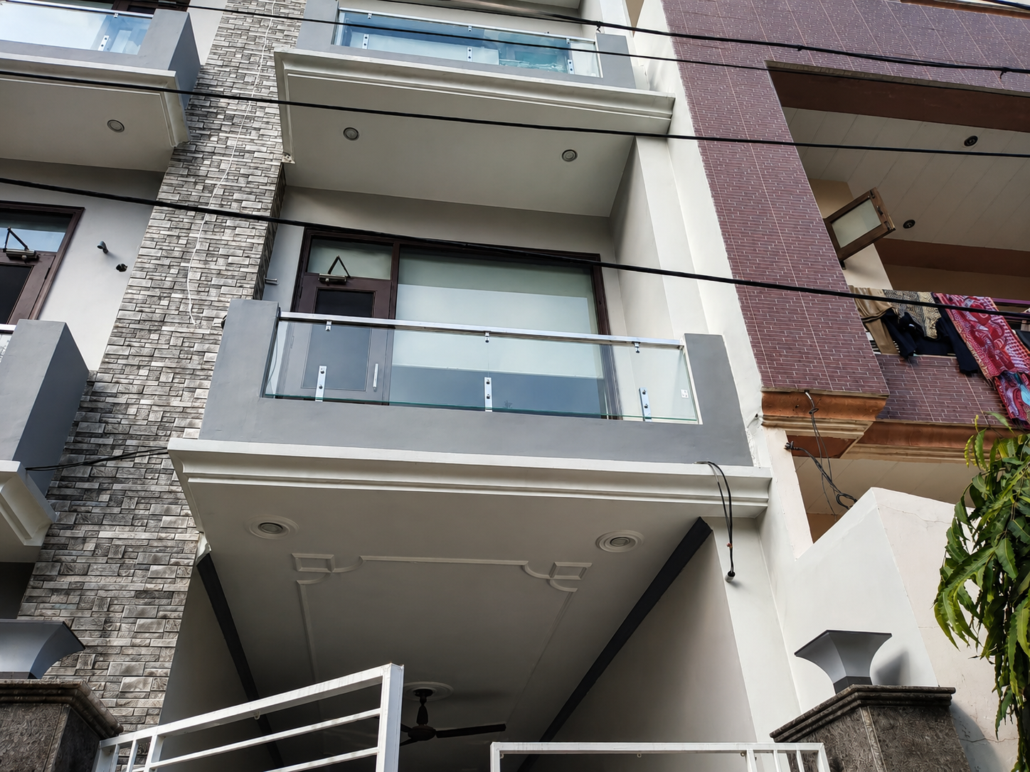 Modern building facade with glass and steel balcony balustrades by Lotey Metalcrafts