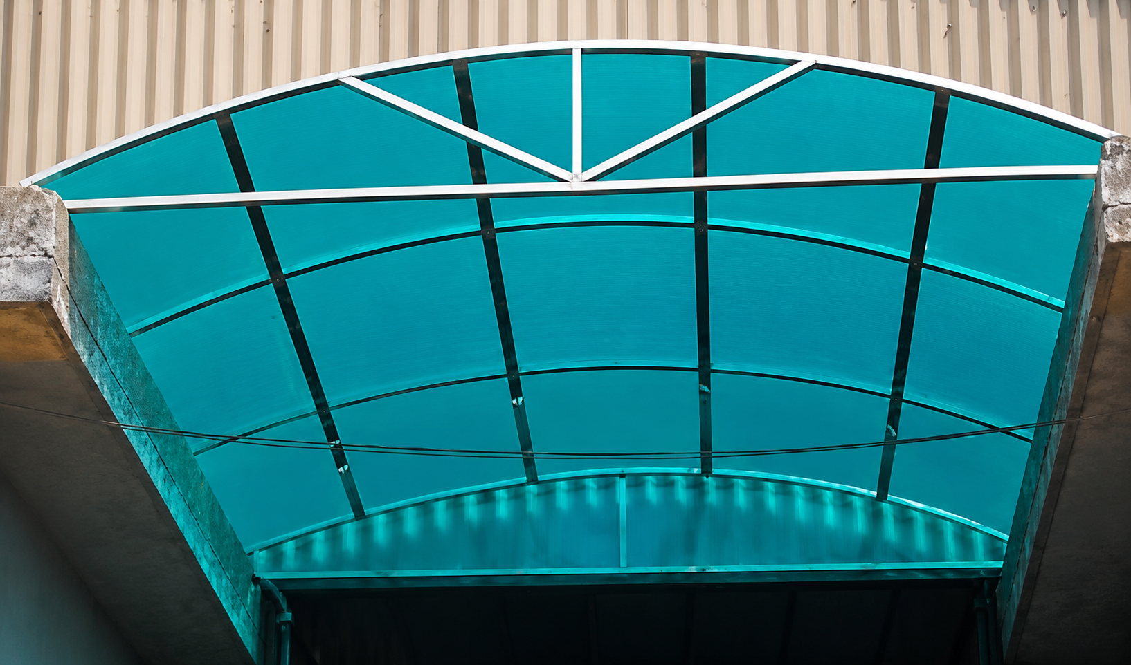 Polycarbonate and steel curved entrance canopy by Lotey Metalcrafts